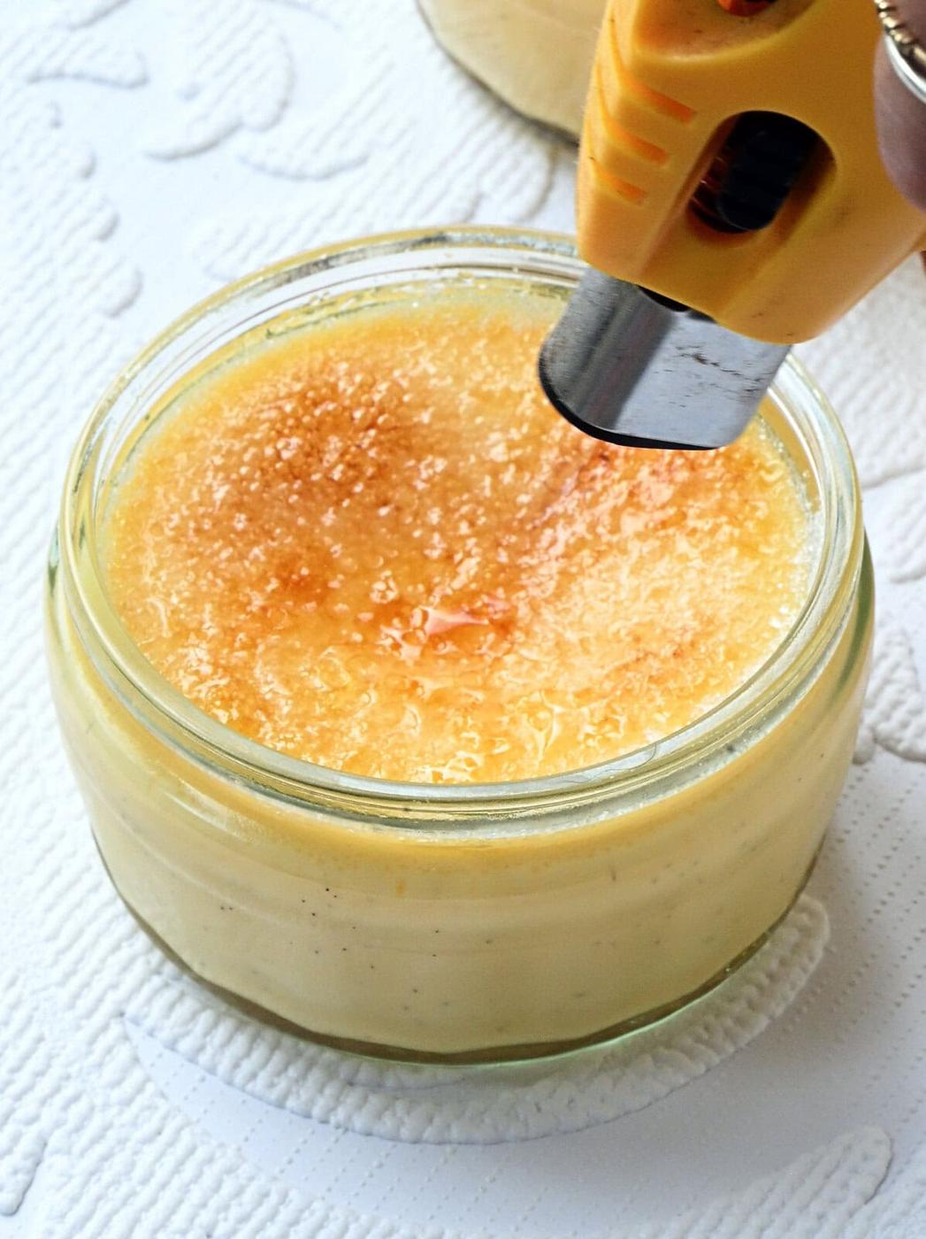 using a blow torch to caramelise sugar on creme brulee