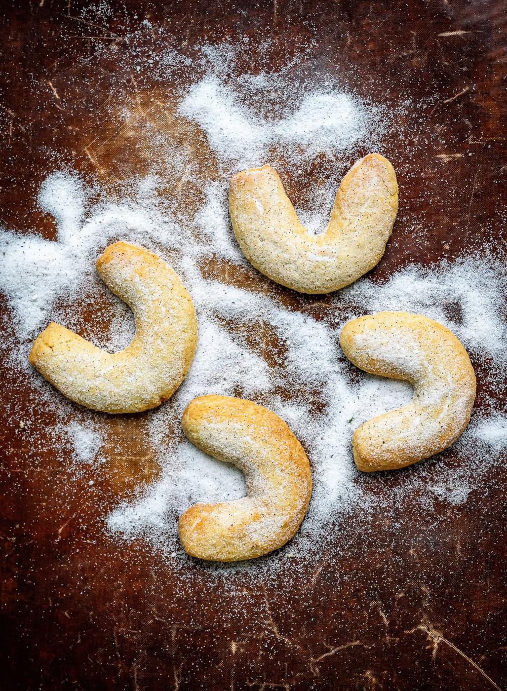 German vanilla crescent cookies dusted with vanilla sugar on a dark background