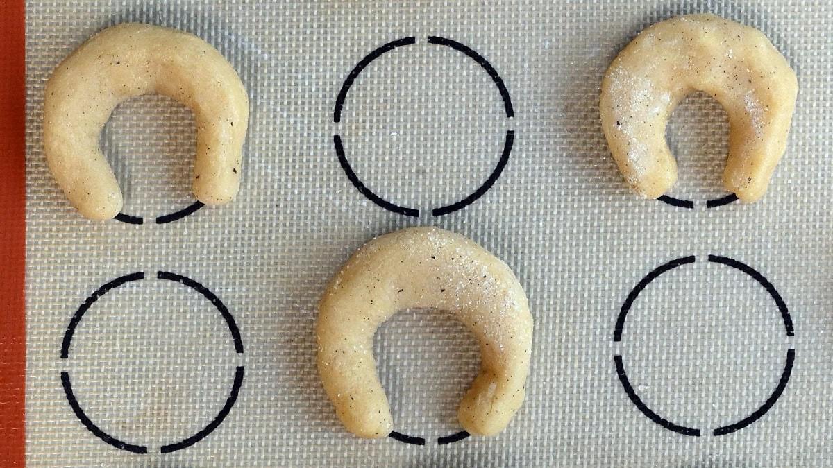 raw vanilla crescent cookies on a silicone mat