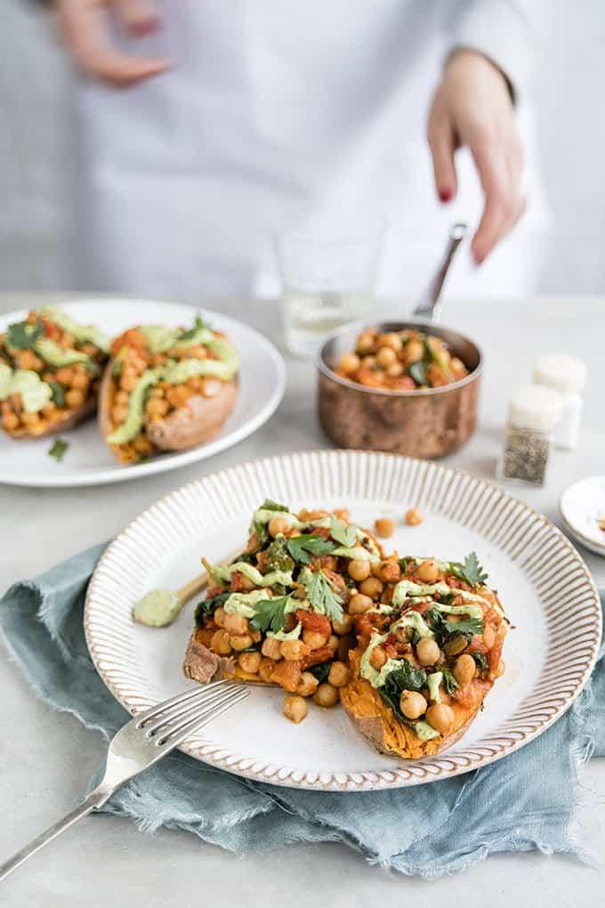 Baked sweet potatoes with spicy chickpeas and green tahini dressing