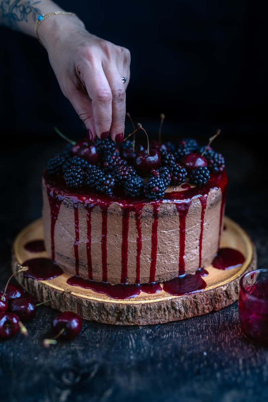 Adding cherries to a vegan chocolate cake