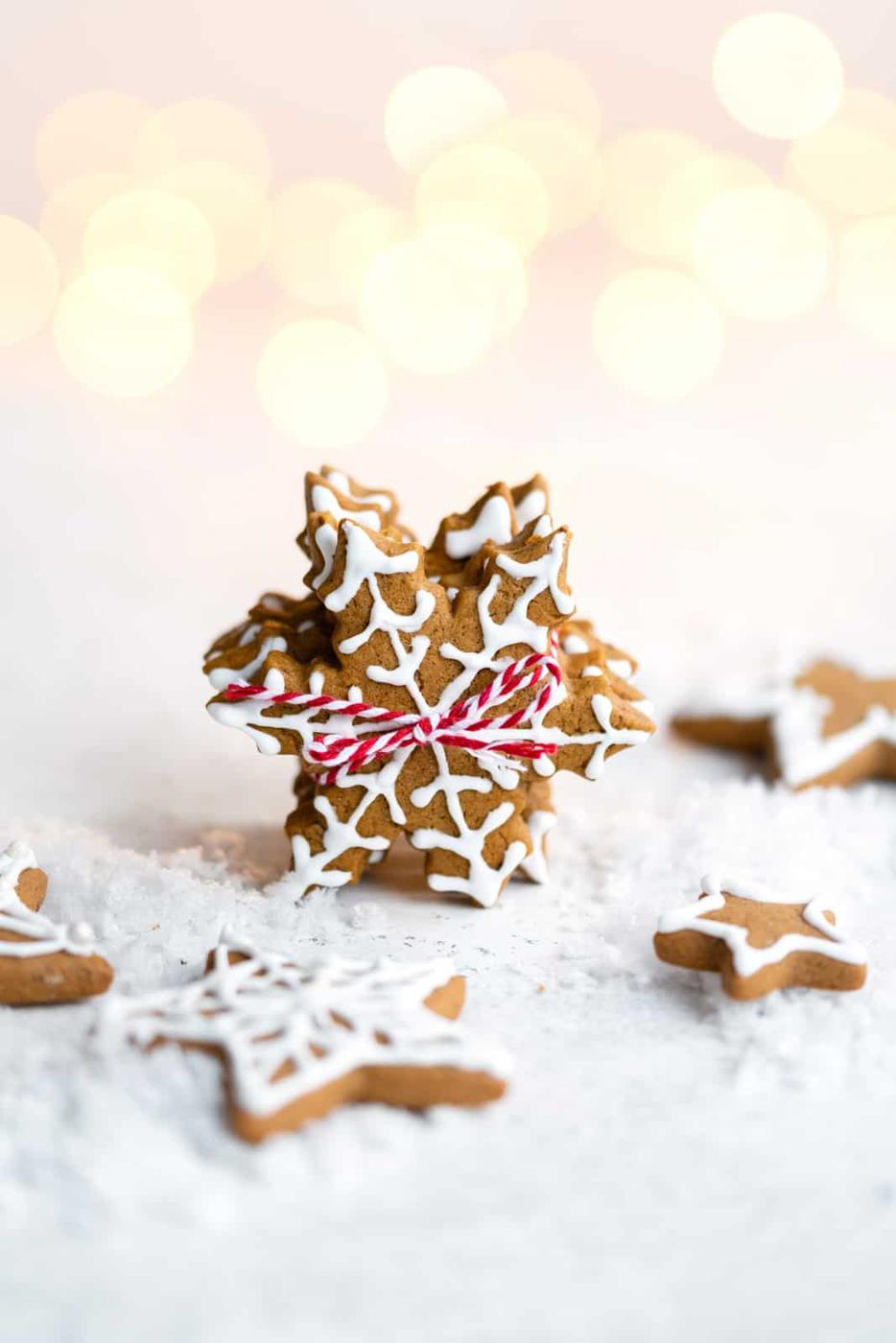 Vegan gingerbread cookies shaped like snowflakes with white icing decoration