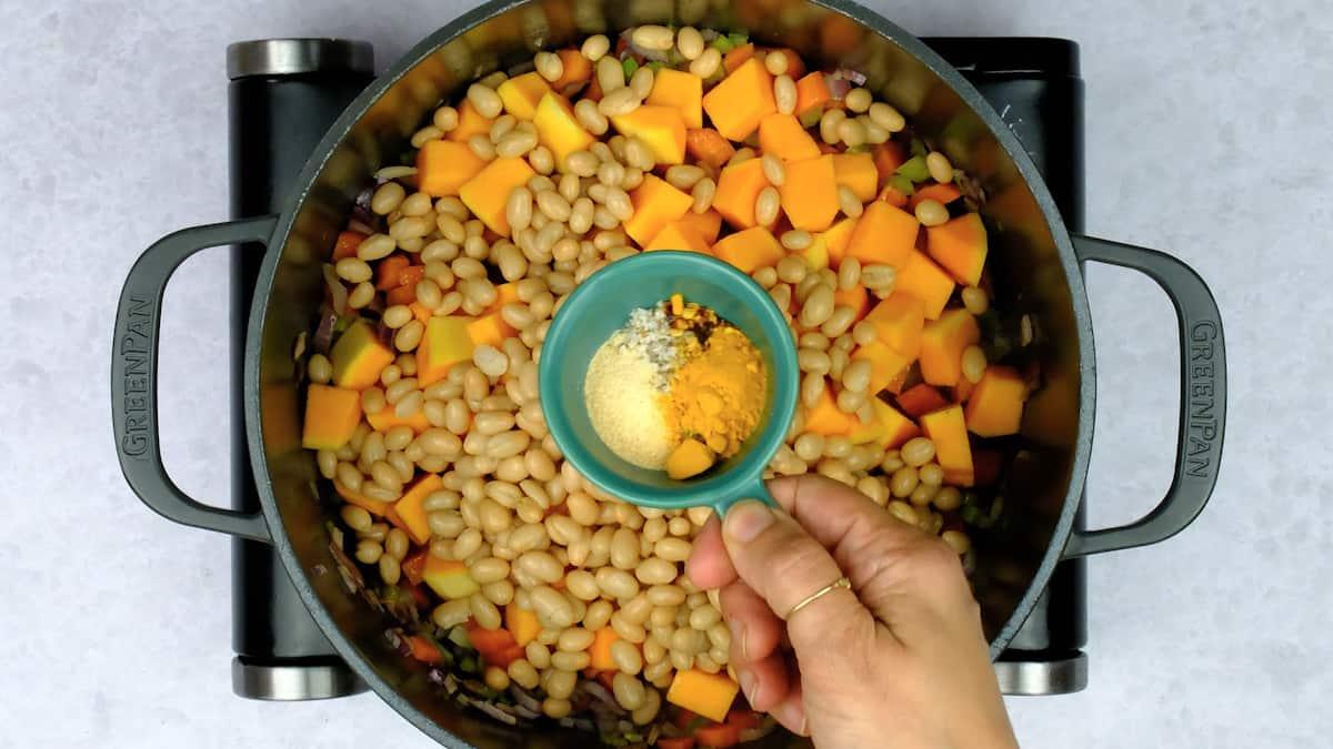 Cooking orzo vegetable soup in a pot