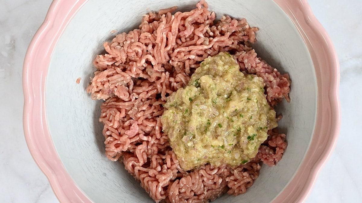 ground pork in a bowl with paste made of shallots, garlic, mint, fish sauce and sugar