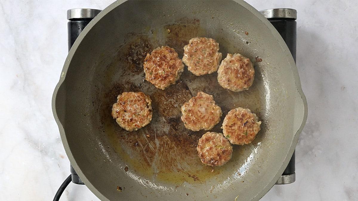 Vietnamese meatballs frying in a pan