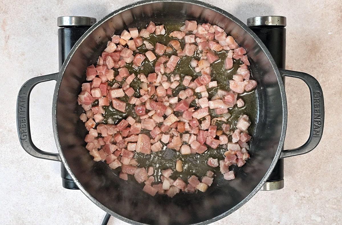cooking cubed pancetta in a Dutch oven