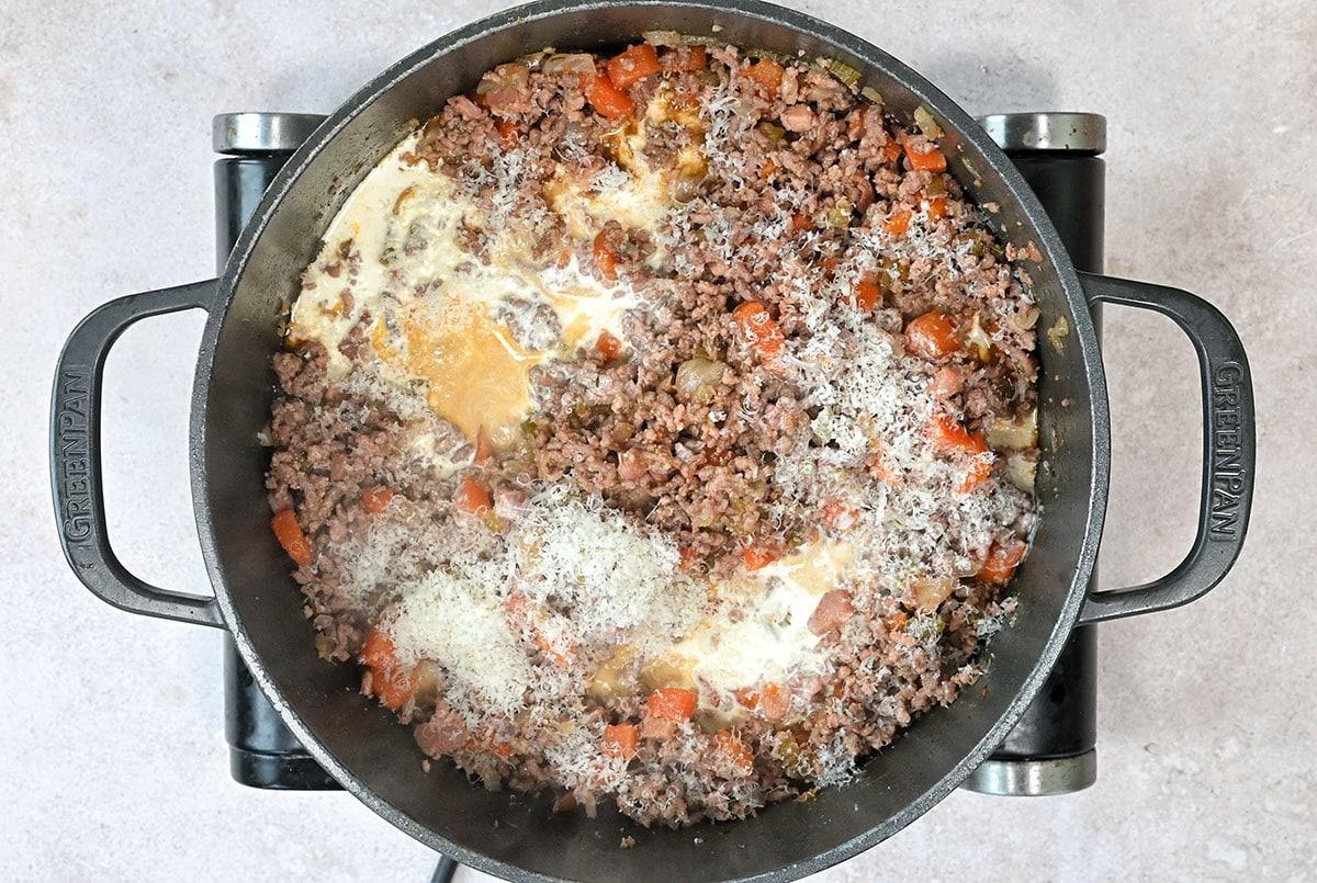 stirring cream and grated Parmesan into white bolognese sauce