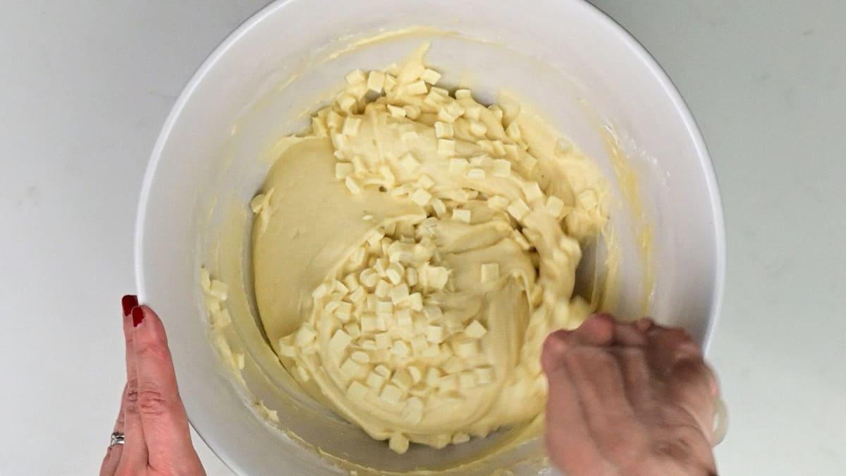Folding white chocolate chunks into cake batter