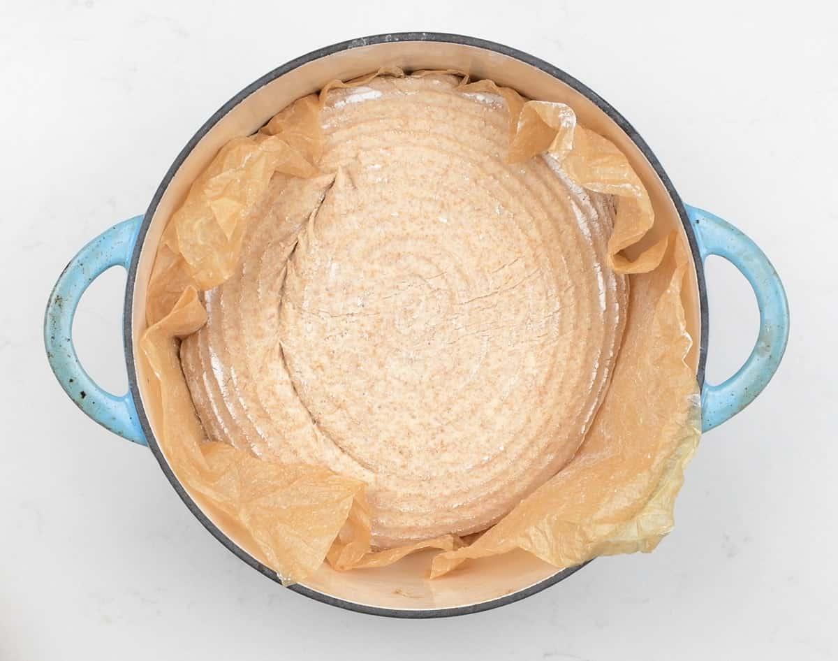 wholemeal bread loaf in a cast iron pot ready to be baked