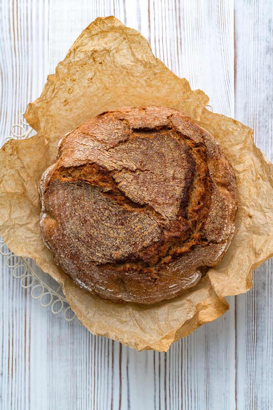 Whole loaf of whole wheat bread on a wire cooling rack